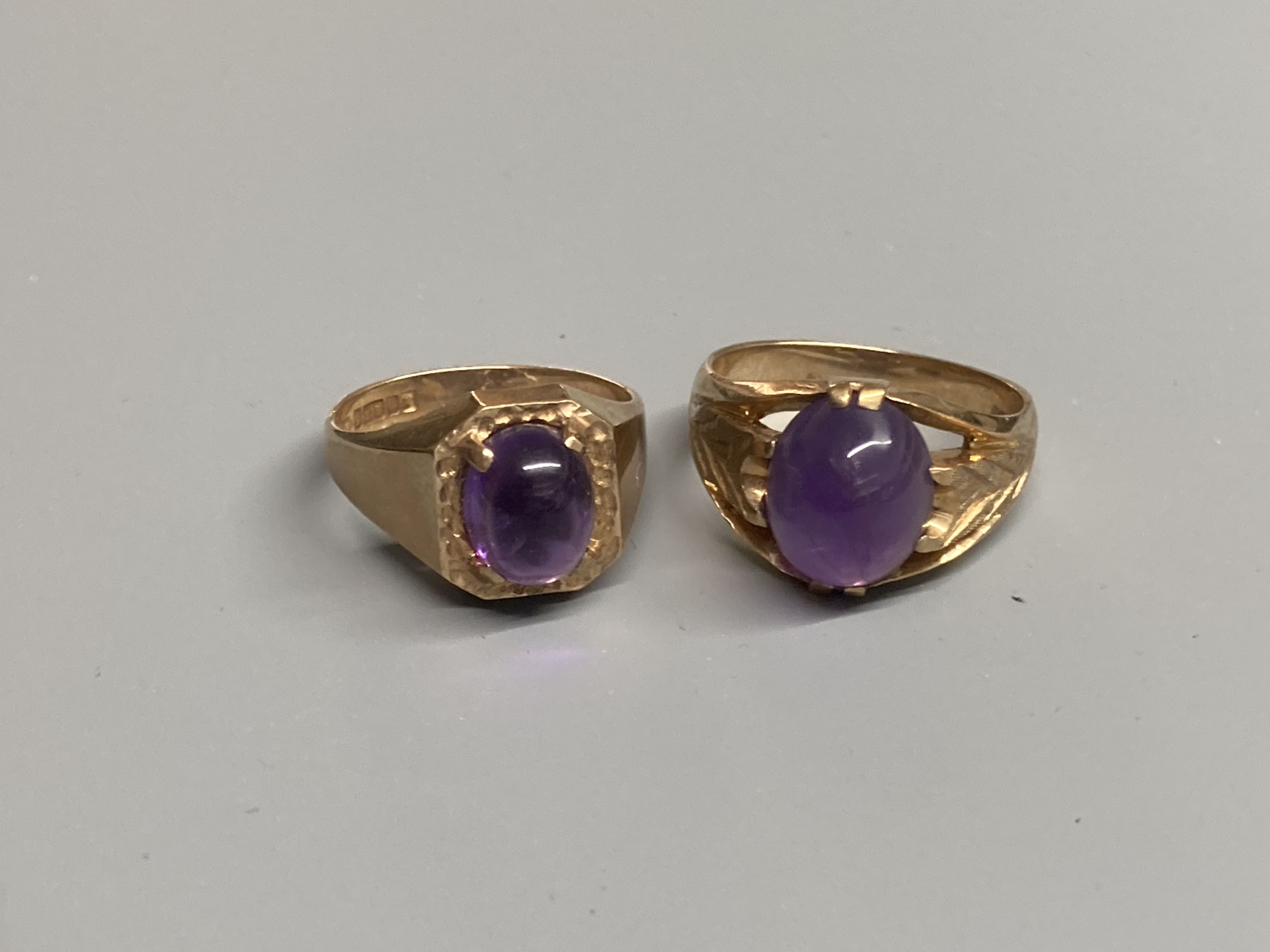 Two modern 9ct gold and cabochon amethyst set dress rings, sizes Q/R & T
